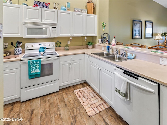 kitchen with a sink, light wood-style flooring, white appliances, light countertops, and white cabinets