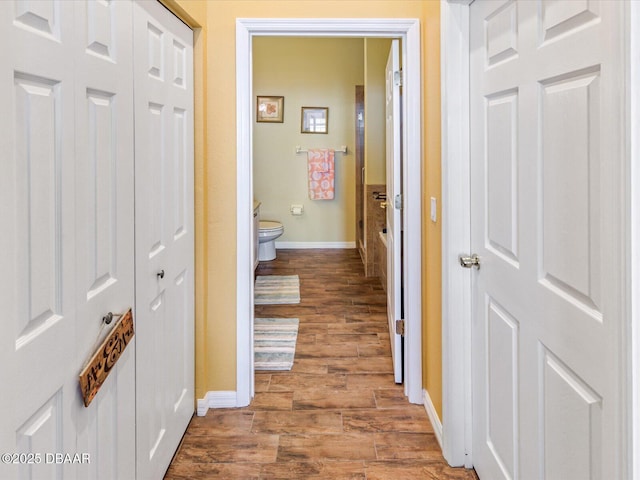 hall featuring baseboards and wood finished floors