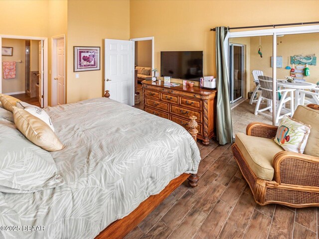 bedroom featuring ensuite bath and wood finish floors