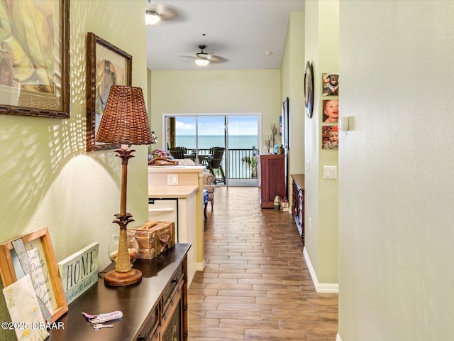 corridor with baseboards and wood finished floors