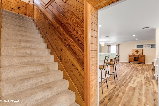 stairway with hardwood / wood-style flooring and wooden walls