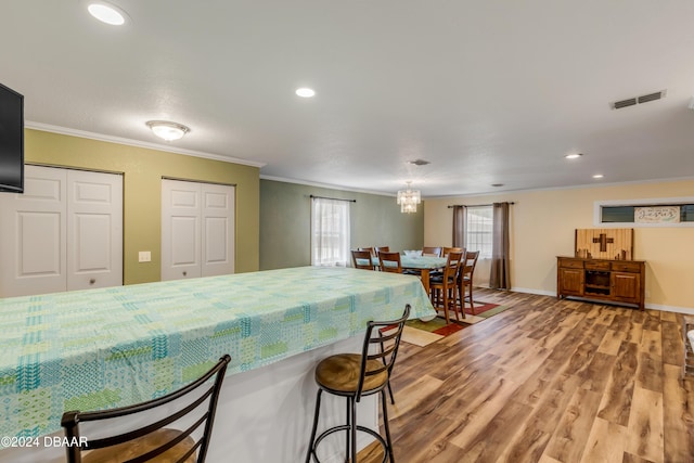 kitchen featuring ornamental molding, light hardwood / wood-style flooring, a healthy amount of sunlight, and a notable chandelier