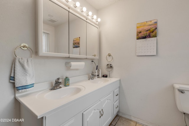 bathroom with tile patterned flooring, vanity, a textured ceiling, and toilet