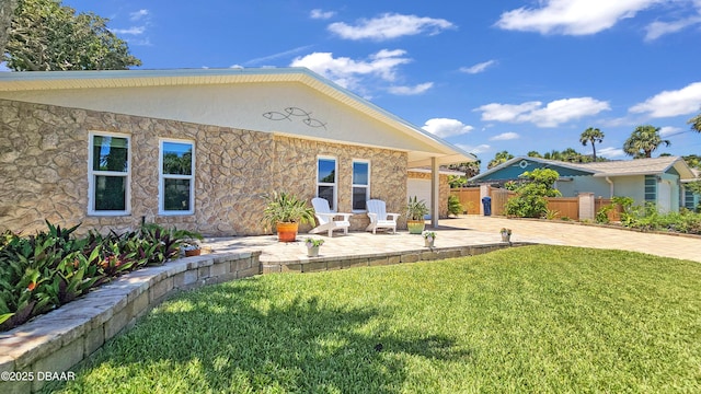 22 Sand Dune Dr, New Smyrna Beach, FL 32169 - back of house with driveway, a patio, an attached garage, and stucco siding