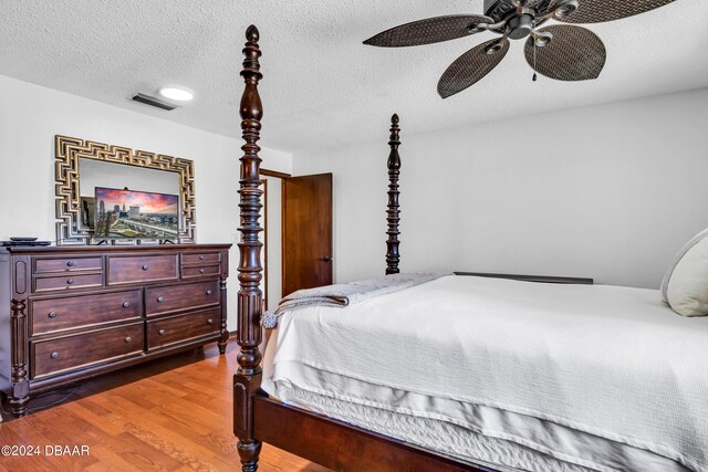 75 Sycamore Cir, Ormond Beach, FL 32174 - bedroom with dark wood-type flooring, a textured ceiling, and ceiling fan