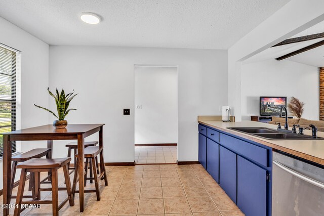 75 Sycamore Cir, Ormond Beach, FL 32174 - kitchen with a textured ceiling, sink, blue cabinetry, stainless steel dishwasher, and light tile patterned flooring