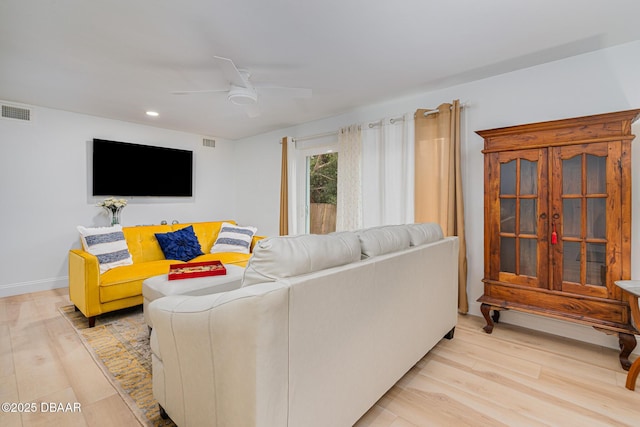 living room featuring ceiling fan and light hardwood / wood-style flooring