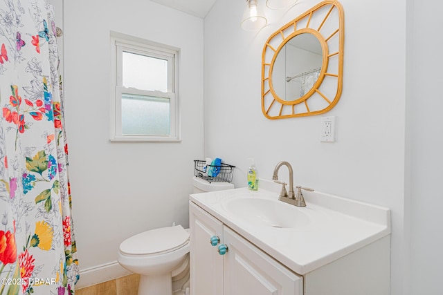 bathroom with hardwood / wood-style floors, toilet, and vanity