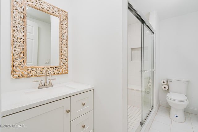 bathroom with toilet, vanity, a shower with door, and tile patterned floors