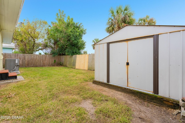 view of yard with central AC unit and a storage shed