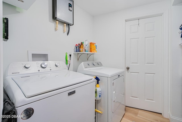 washroom with washing machine and dryer and light hardwood / wood-style floors