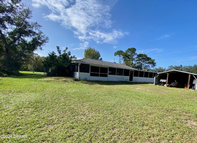 view of yard featuring a sunroom and a carport