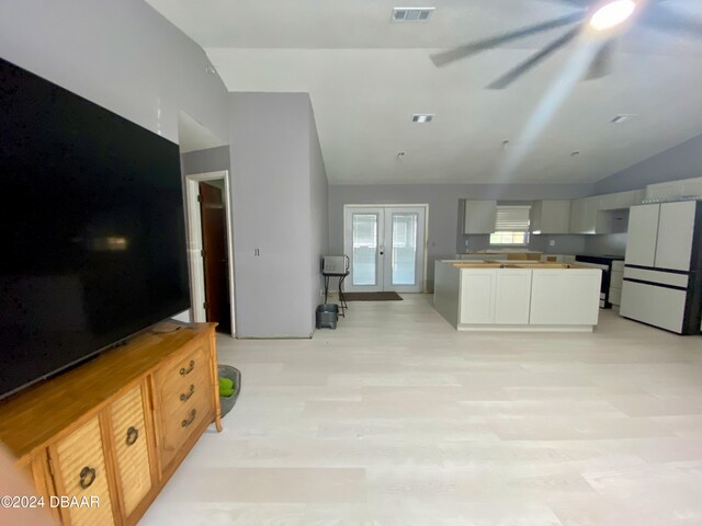 kitchen with white refrigerator, vaulted ceiling, and french doors