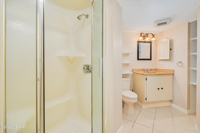 bathroom with tile patterned floors, vanity, toilet, and a shower with shower door