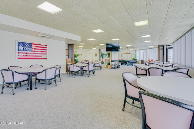 dining space with a drop ceiling and carpet floors