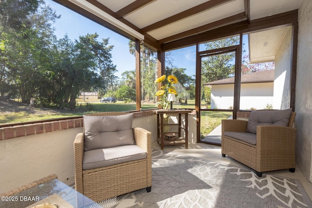 sunroom / solarium featuring lofted ceiling with beams