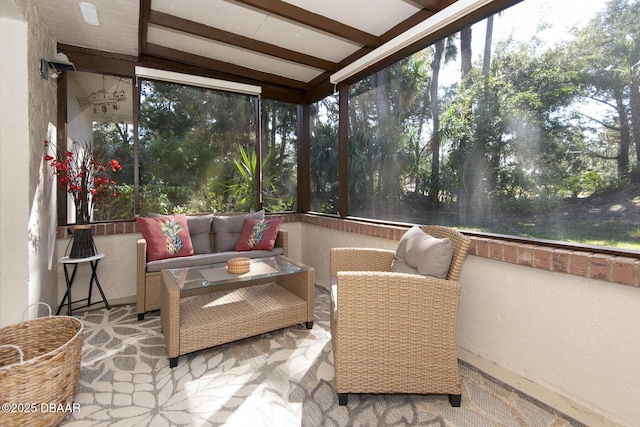 sunroom / solarium featuring beamed ceiling