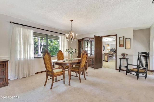 carpeted dining area with a notable chandelier and a textured ceiling