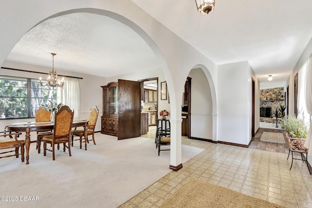 dining area featuring an inviting chandelier and a textured ceiling