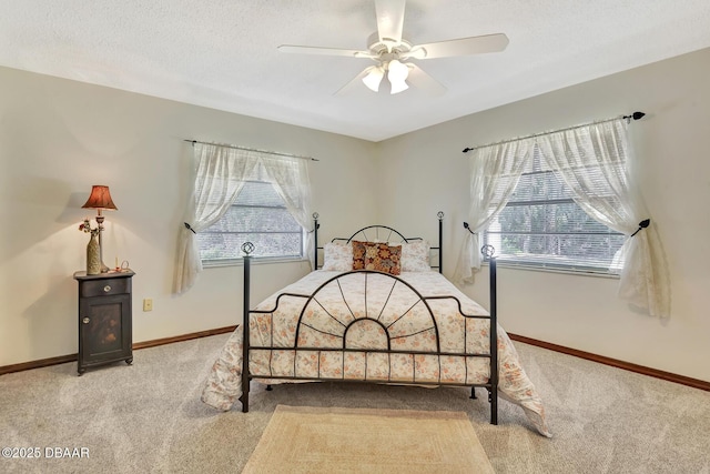 bedroom featuring light carpet, ceiling fan, and a textured ceiling