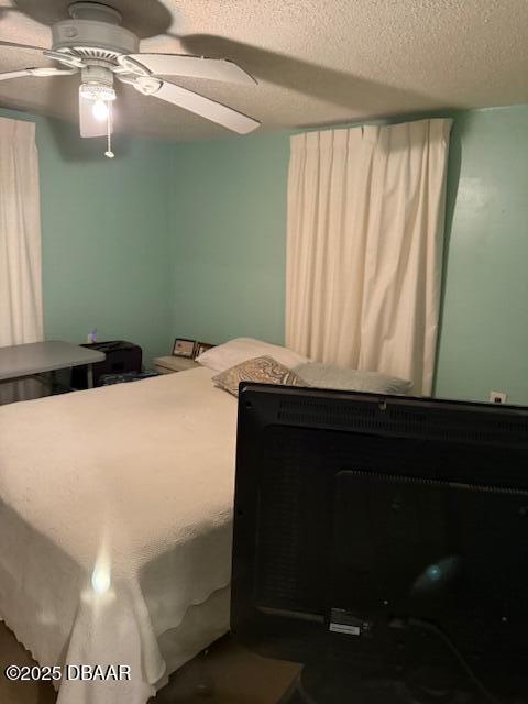 bedroom featuring ceiling fan and a textured ceiling