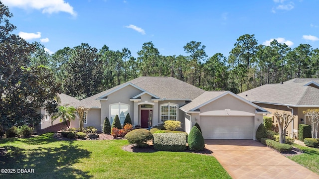 ranch-style house with roof with shingles, driveway, an attached garage, stucco siding, and a front lawn