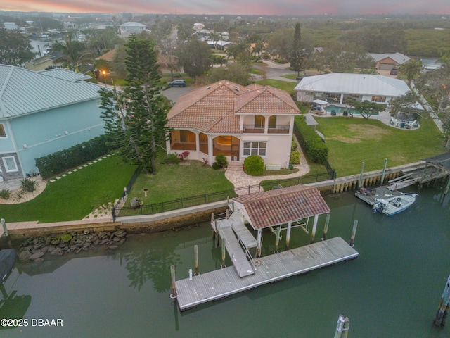 aerial view at dusk featuring a water view