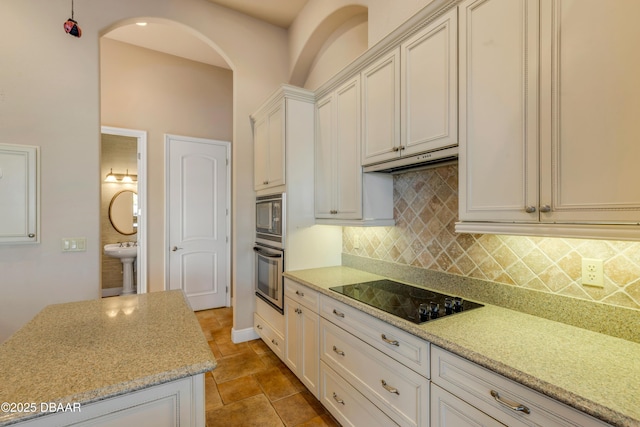 kitchen with backsplash, stainless steel oven, built in microwave, under cabinet range hood, and black electric cooktop