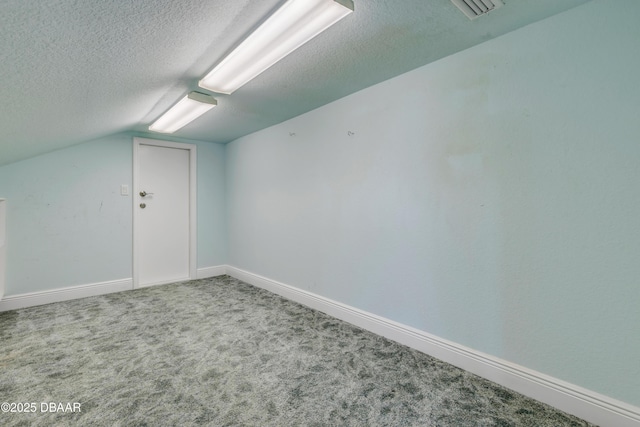 bonus room with carpet floors, visible vents, vaulted ceiling, a textured ceiling, and baseboards