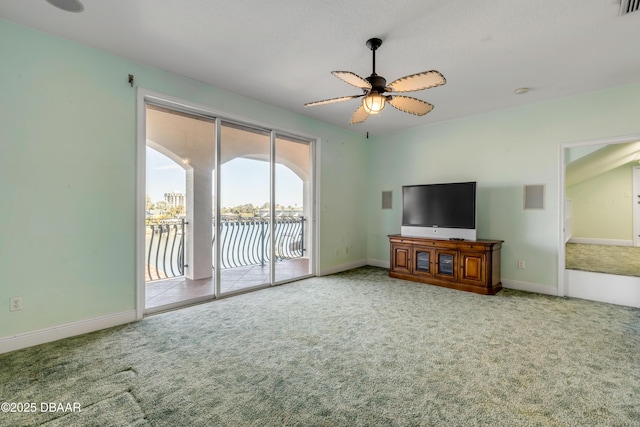 unfurnished living room with carpet, baseboards, and a ceiling fan