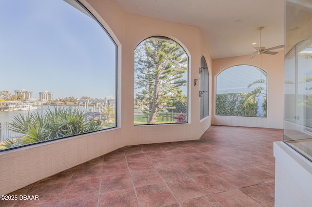 view of patio / terrace with a ceiling fan and a water view