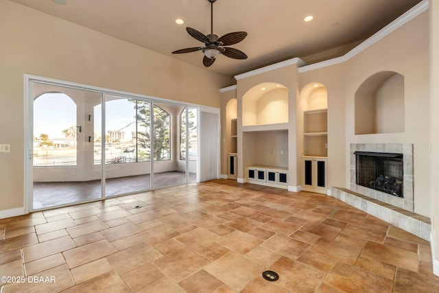 unfurnished living room with built in features, recessed lighting, a tiled fireplace, ceiling fan, and baseboards