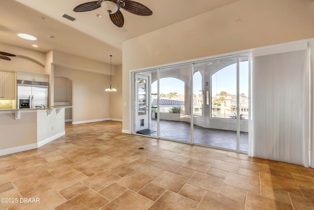 interior space featuring recessed lighting, ceiling fan with notable chandelier, visible vents, baseboards, and stone finish floor