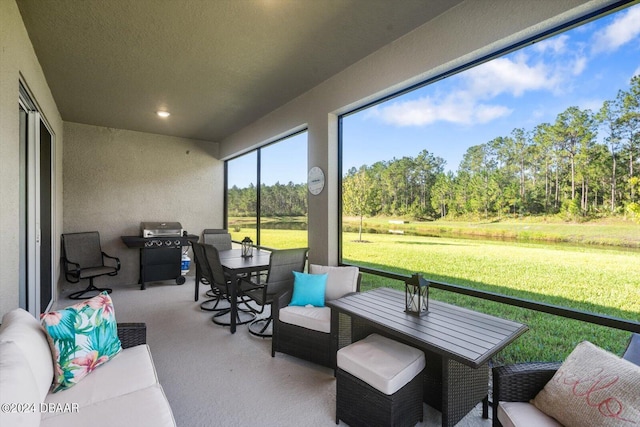 sunroom / solarium featuring view of scattered trees