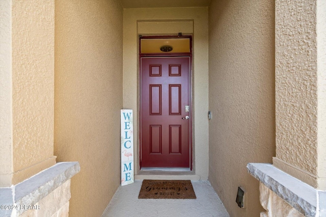 property entrance with stucco siding