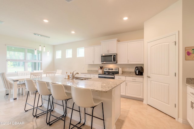 kitchen featuring a wealth of natural light, sink, an island with sink, and appliances with stainless steel finishes