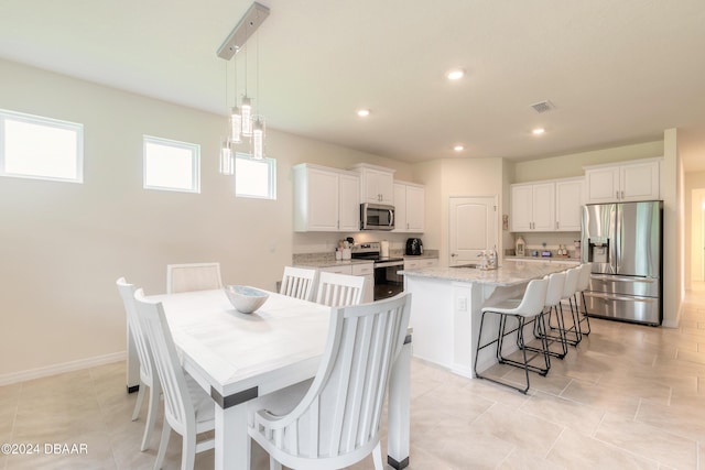 dining space with recessed lighting, light tile patterned floors, and baseboards