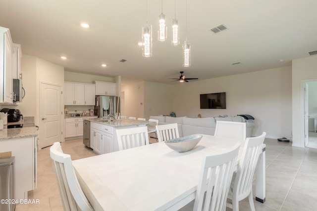 dining space featuring light tile patterned floors and ceiling fan