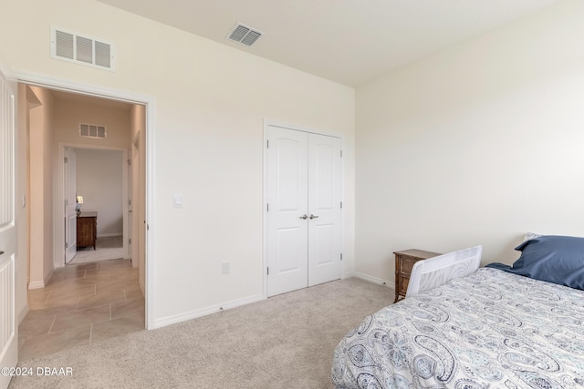 bedroom with light colored carpet, baseboards, and a closet