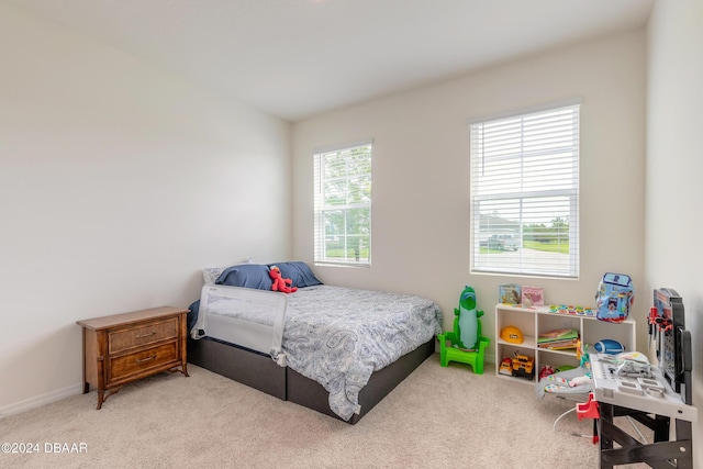 bedroom with light carpet and baseboards