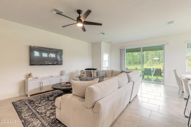 tiled living room featuring ceiling fan