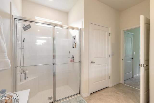 bathroom with a stall shower and tile patterned floors