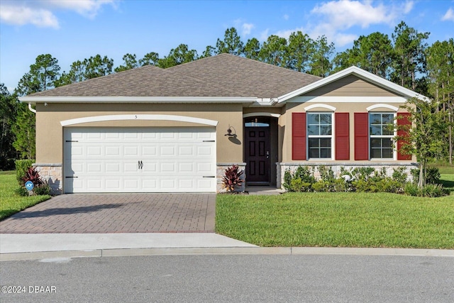 single story home featuring a front lawn and a garage