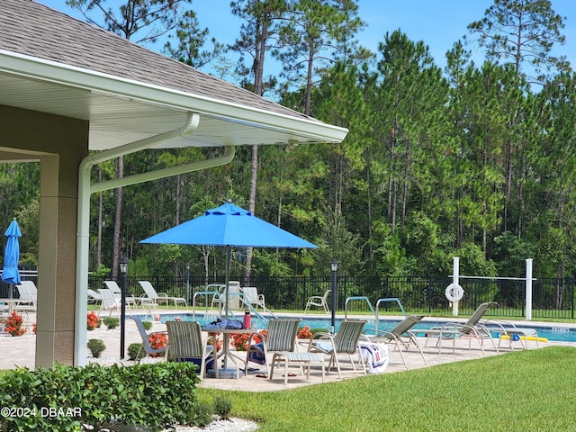 community pool with a patio and fence