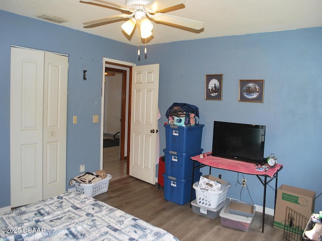bedroom featuring wood finished floors, a closet, a ceiling fan, and visible vents