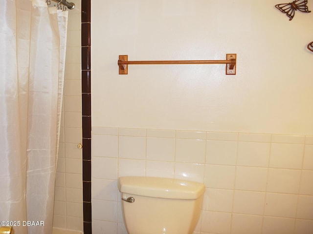 bathroom featuring toilet and a shower with shower curtain