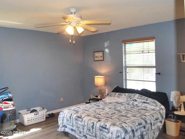 bedroom featuring baseboards, a ceiling fan, and wood finished floors