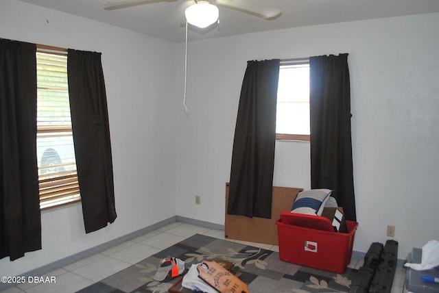 unfurnished room with ceiling fan, baseboards, and light tile patterned floors