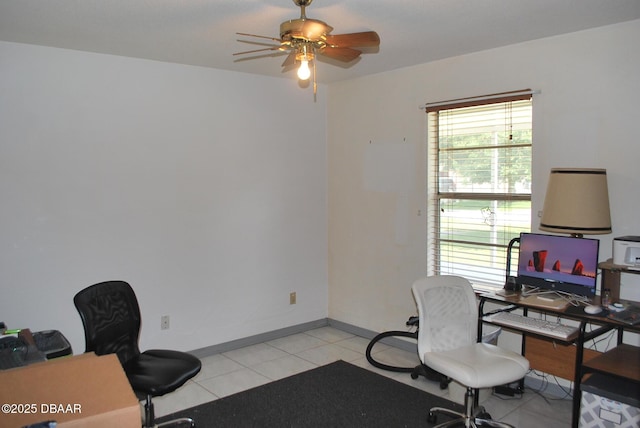 home office with a ceiling fan, baseboards, and light tile patterned floors