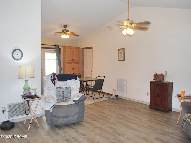 living area featuring vaulted ceiling, visible vents, a ceiling fan, light wood-type flooring, and baseboards